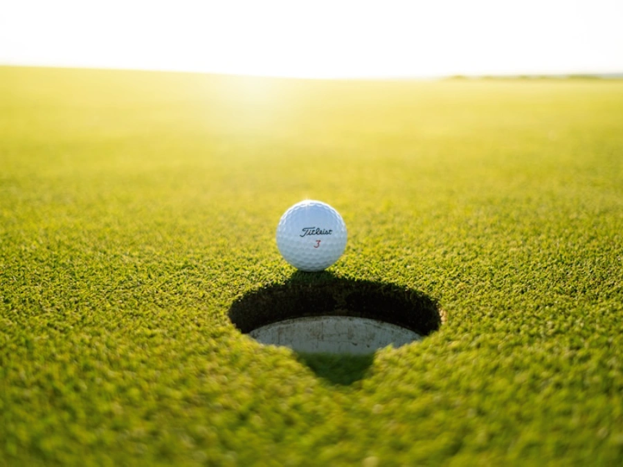 Golfer taking a swing on a beautiful green golf course